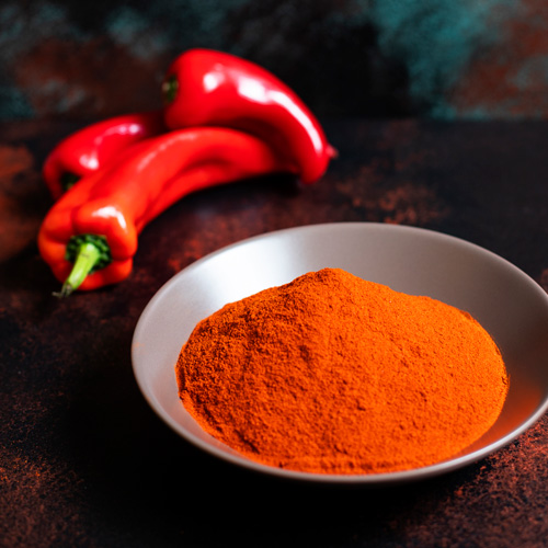 paprika powder in bowl with fresh paprika